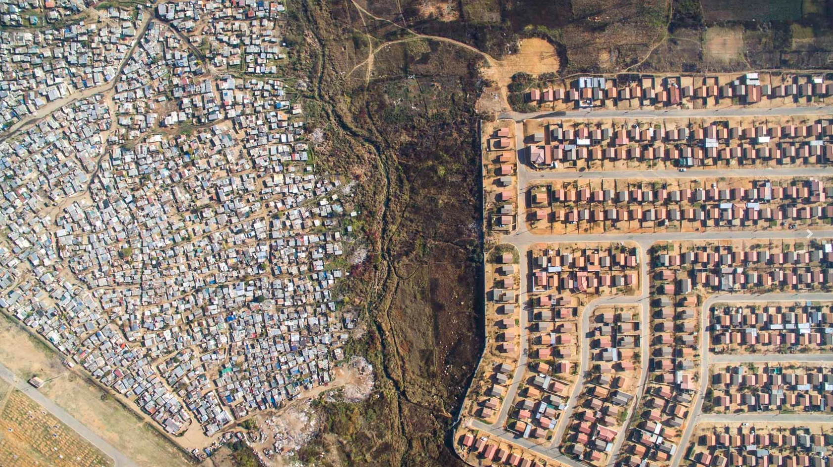 High above the shacks of the Vusimuzi settlement, power lines carry electricity to wealthier suburbs of Johannesburg, South Africa