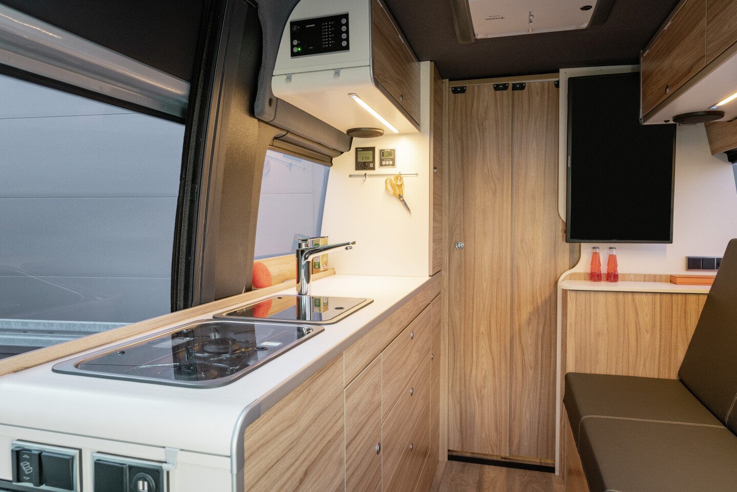 By eliminating the central bathroom compartment and standing height fridge/cabinet, Hymer pushes the walls toward the rear and opens up the main living space