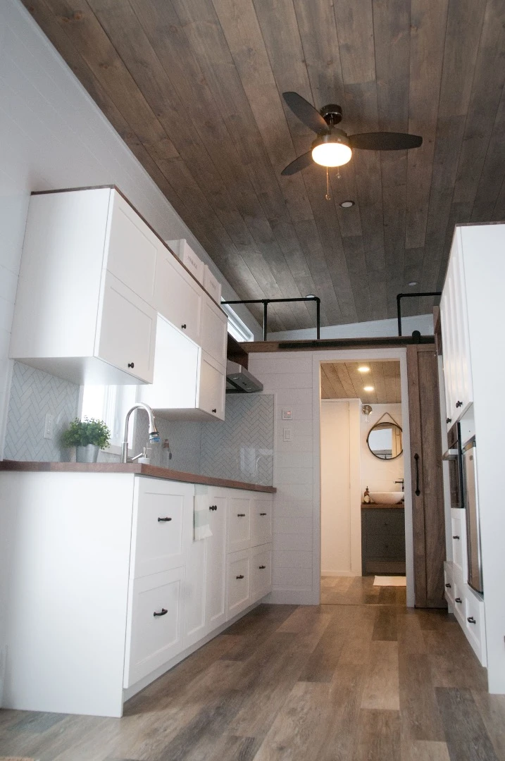 The Ébène's kitchen includes two freezers, a fridge, stainless steel sink, induction stove, and a microwave/oven