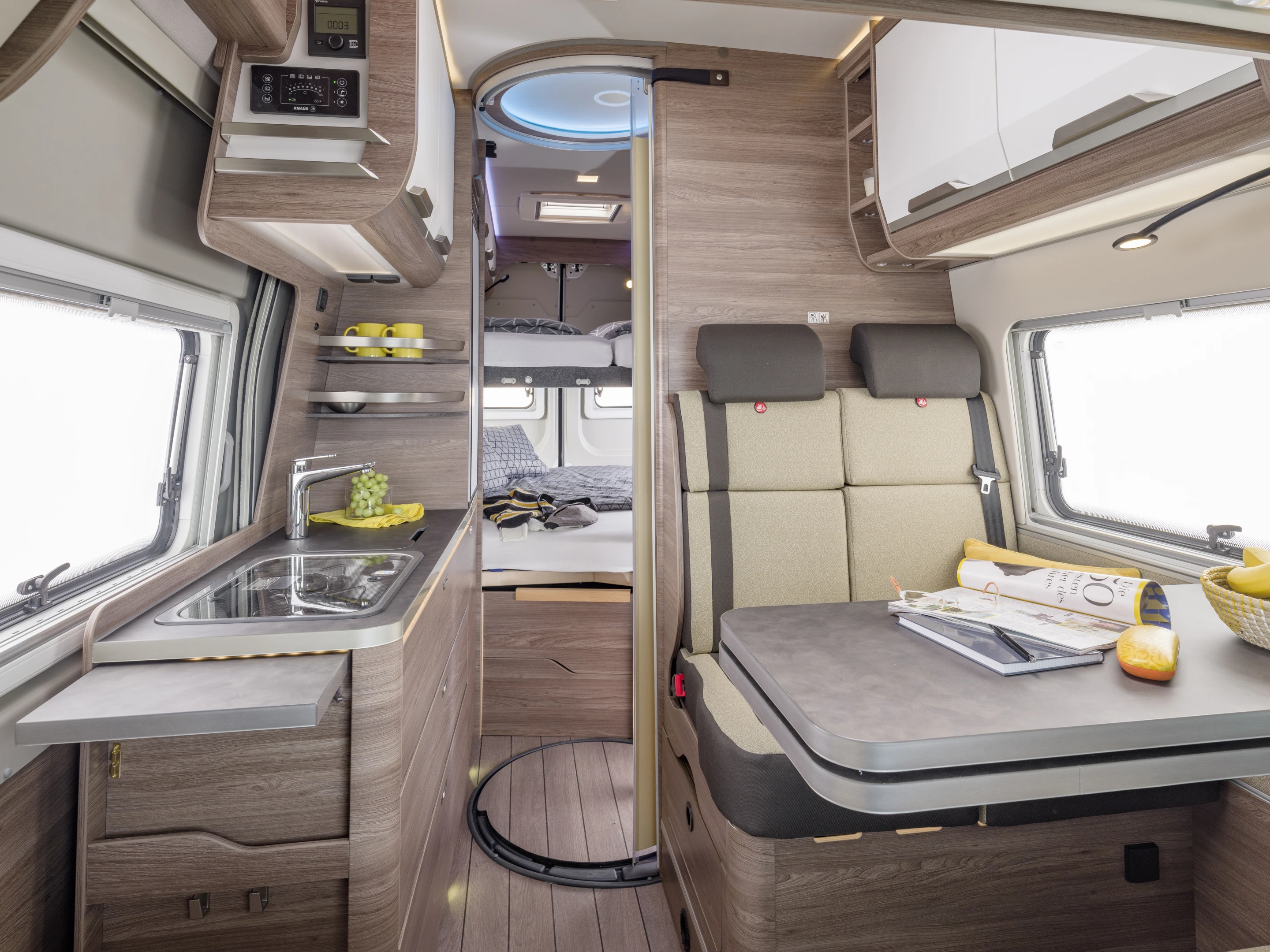 The interior features a front dinette, central bathroom and kitchen block