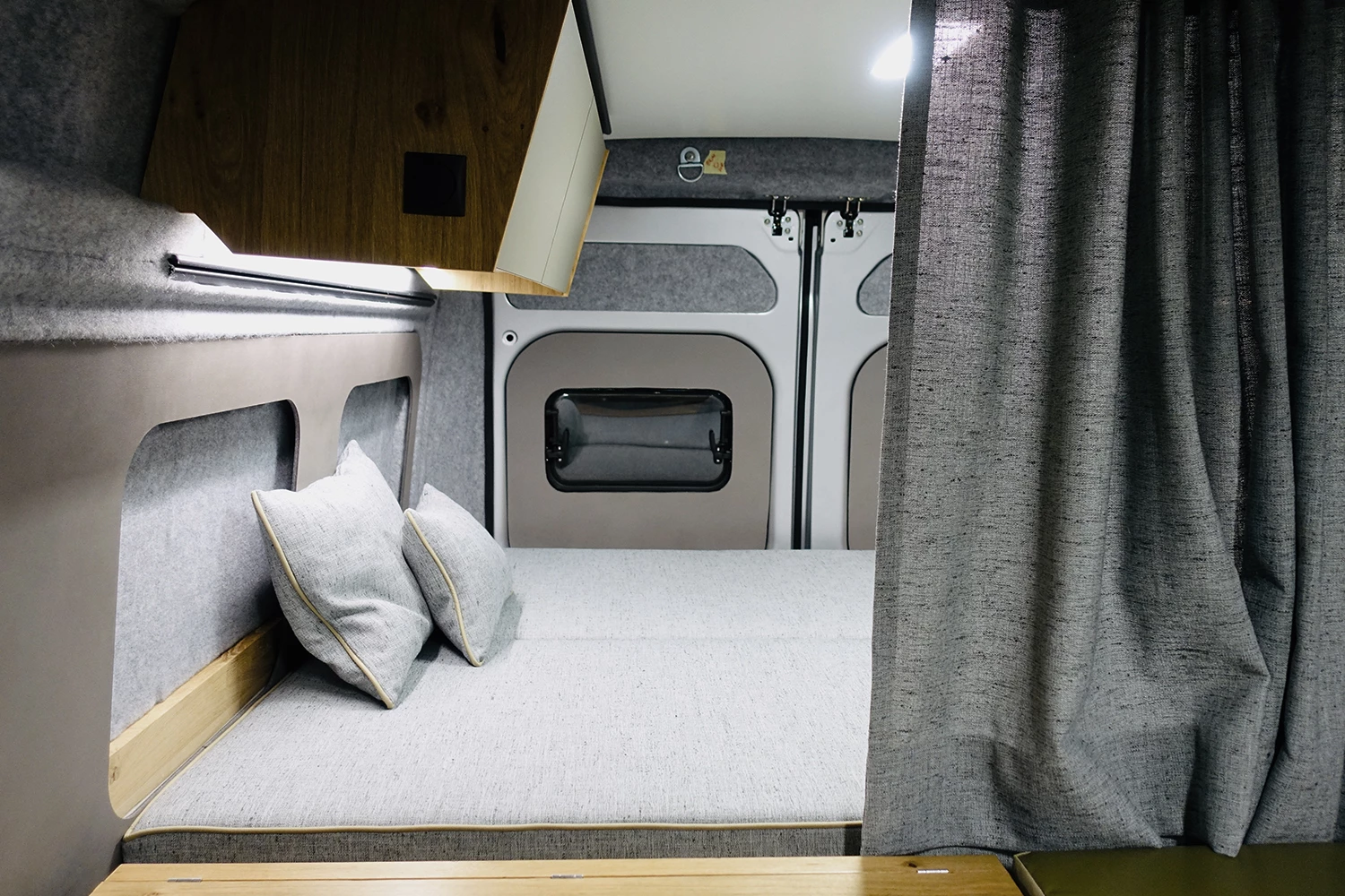 The rear bed is raised over a lower storage garage and separated from the living area by a curtain