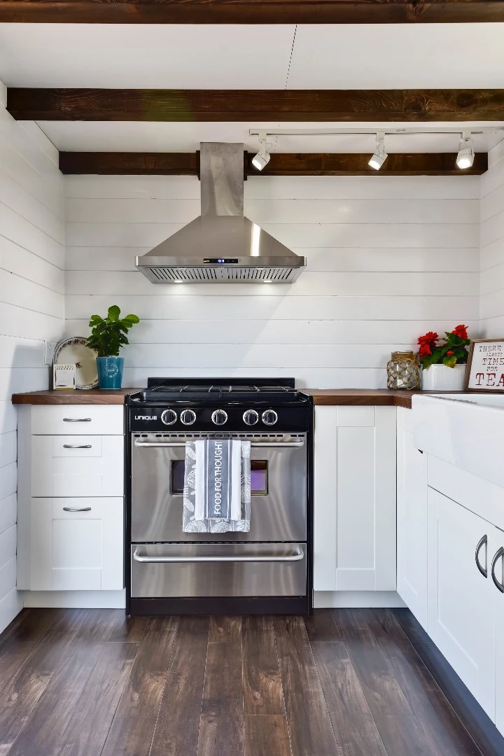 The kitchen includes a stainless steel fridge/freezer and propane-powered oven