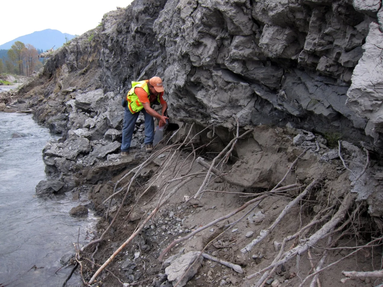 US Geological Survey civil engineer Brian Collins examines gray clay deposits overlying the brown sand that forms the underlying alluvial river valley