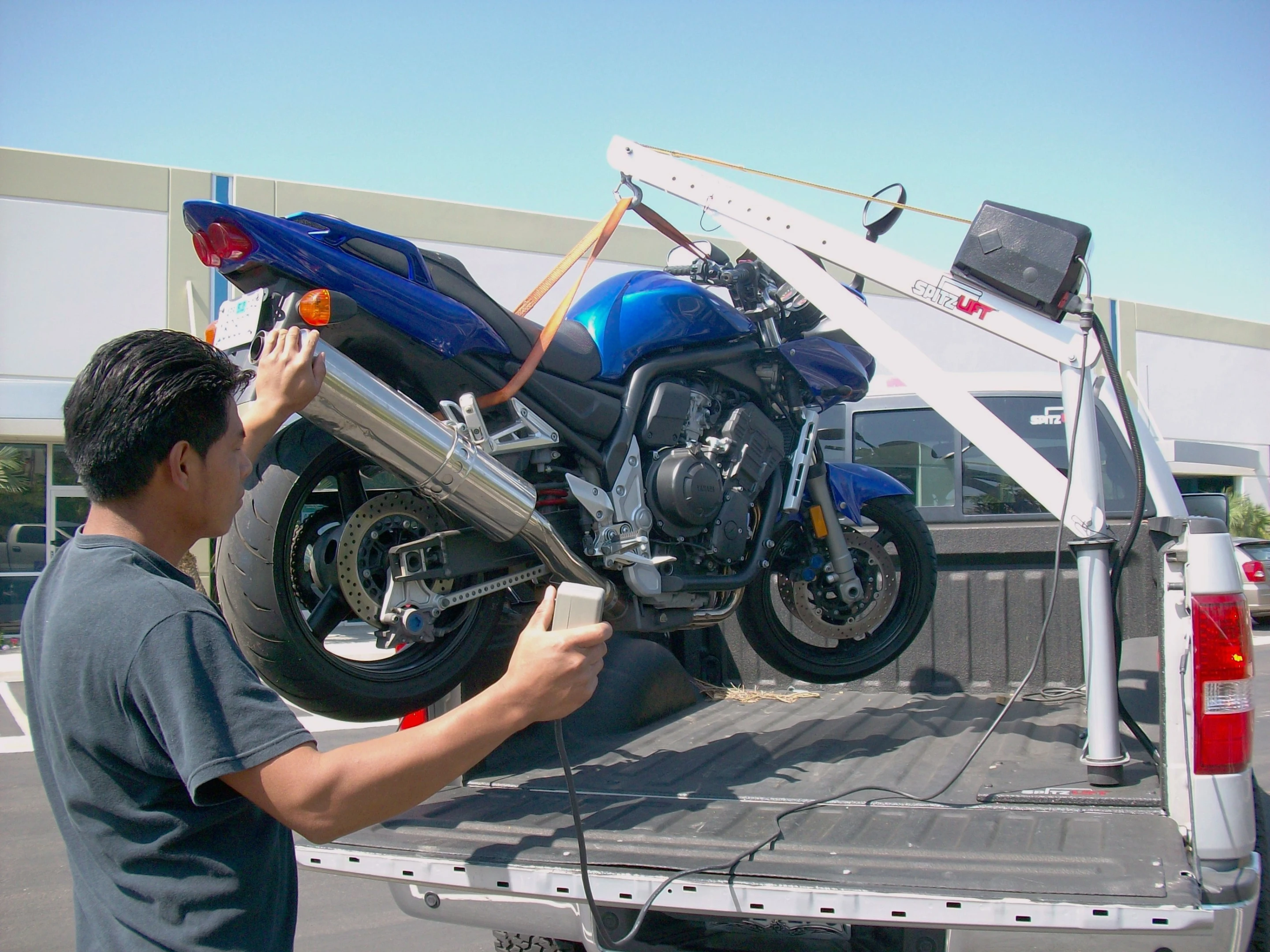 Spitzlift's miniature cranes make lifting a bike into a truck easy