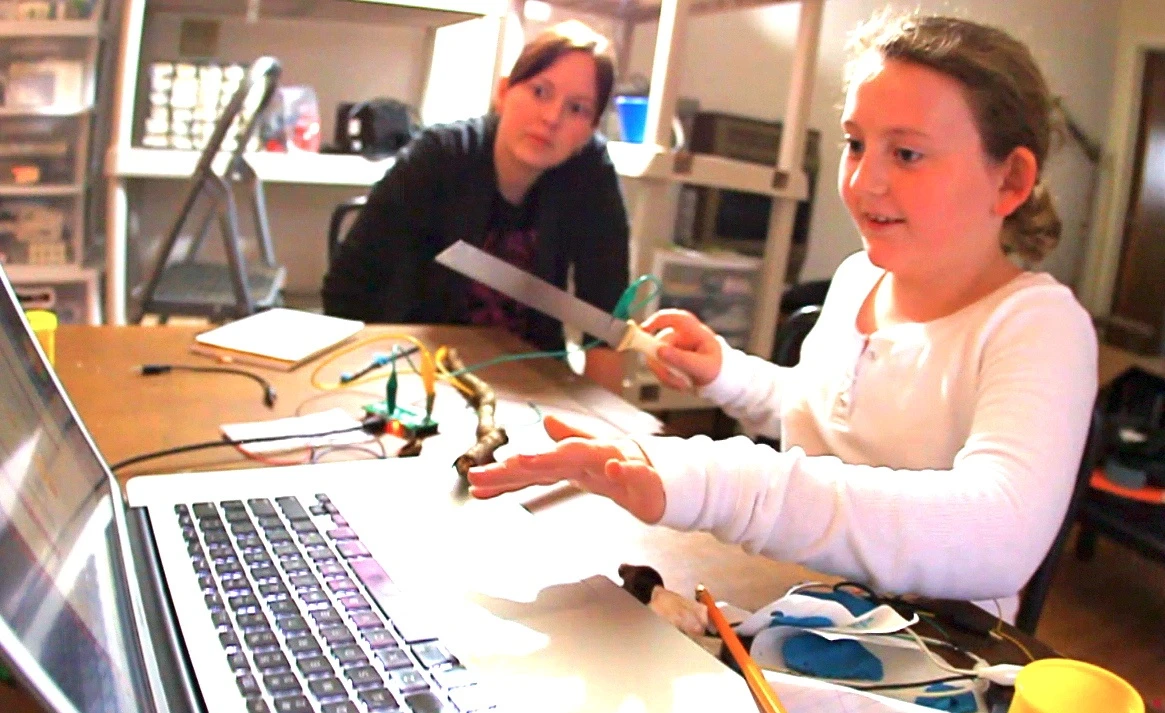 An 8 year-old user creates a knife-and-log interface for cutting virtual wood in an online game
