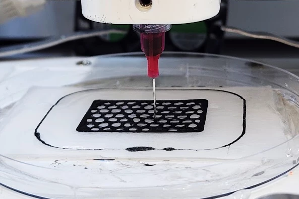 The ink instantly forms into a solid grid when extruded onto a salt-water-covered glass slide