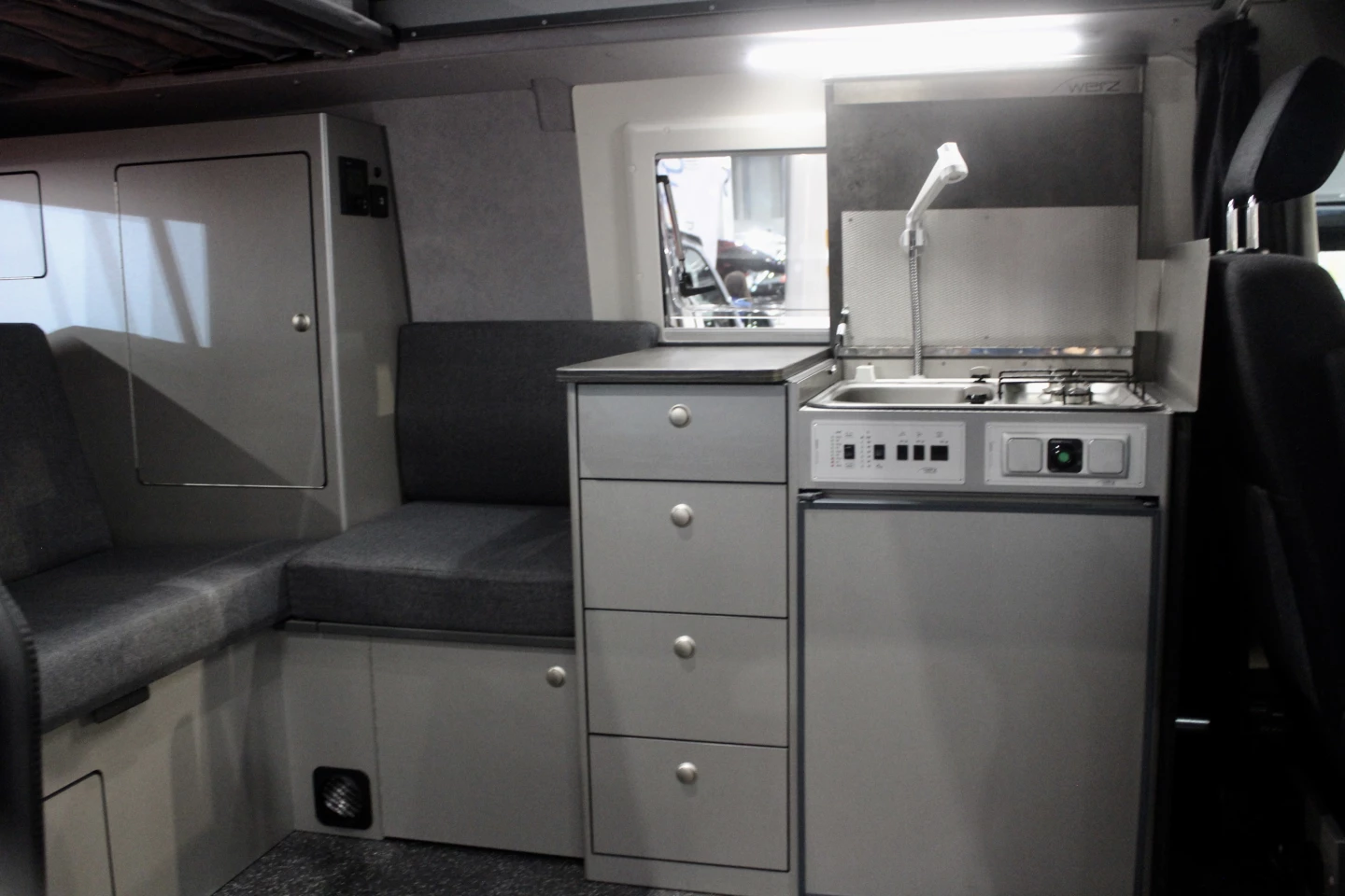 Werz fills its Magnum B interior out a little differently, with a compact wraparound sofa, tall drawer console and compact kitchen block