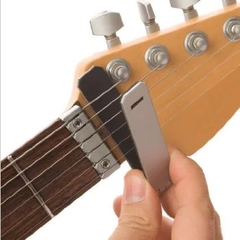 First snap the bracket over the strings after the end of the fretboard