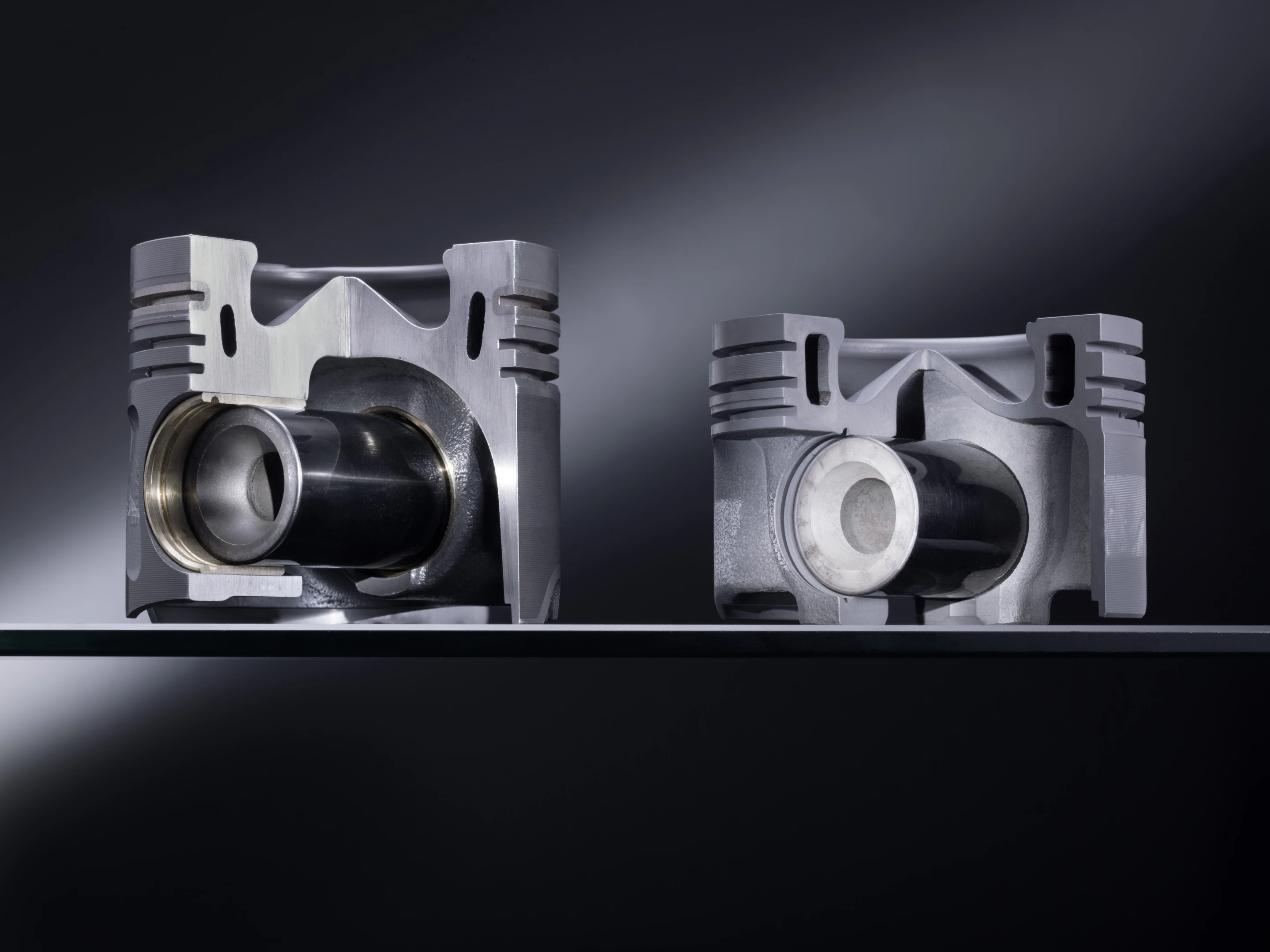 An aluminum piston (left) and one of the new steel pistons (right)