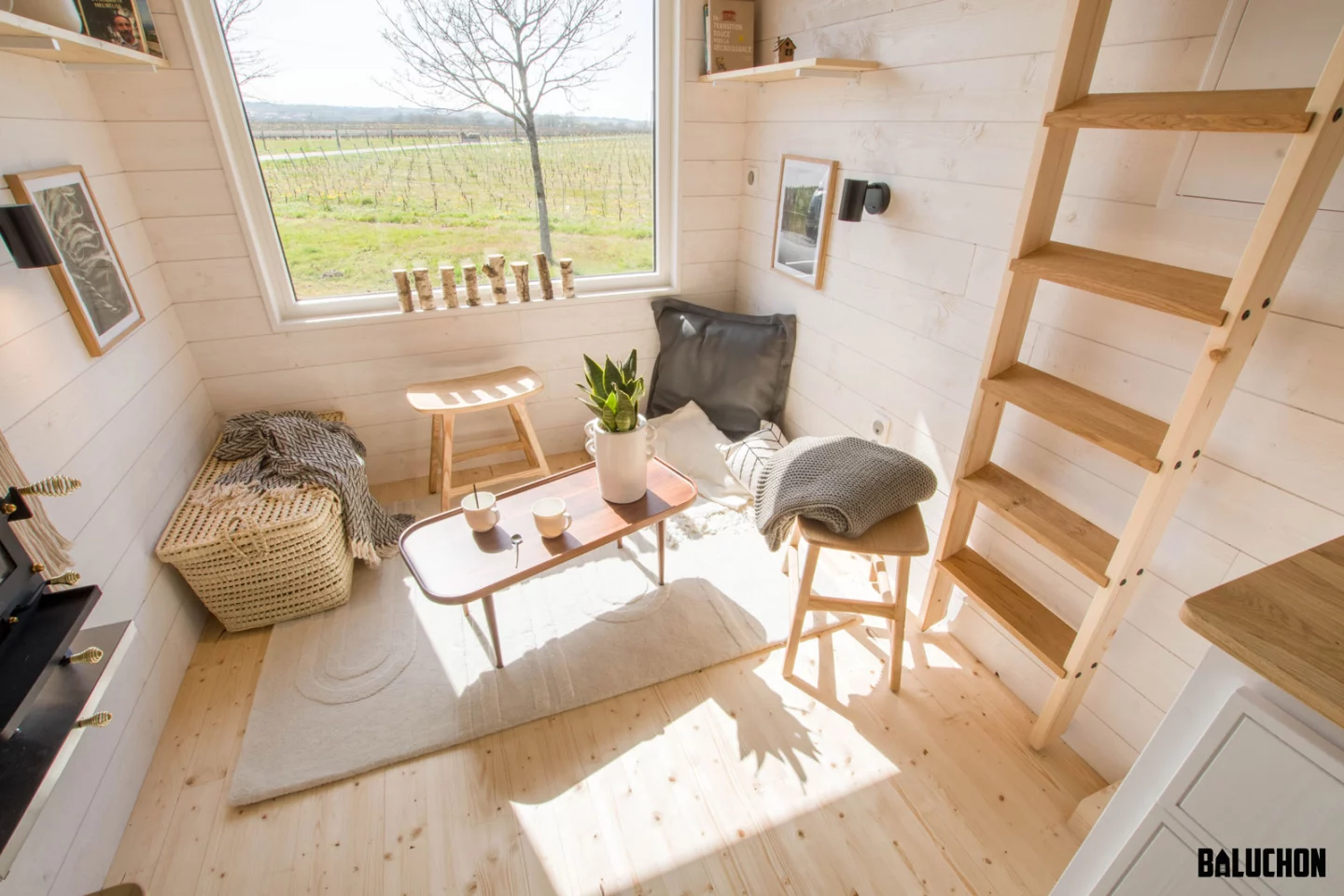 The Tiny House Pétillante's living room is filled with natural light thanks to a large window that also frames the view