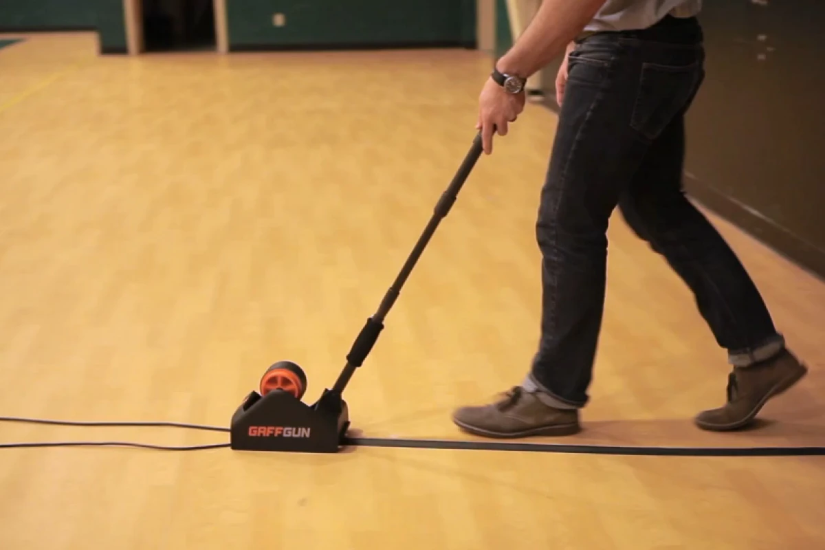 The GaffGun straightens, centers and tapes down cords and cables