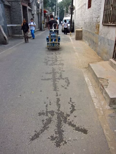 Artist Nicholas Hanna has created a cargo tricycle-based system that prints Chinese calligraphy on the road, in water
