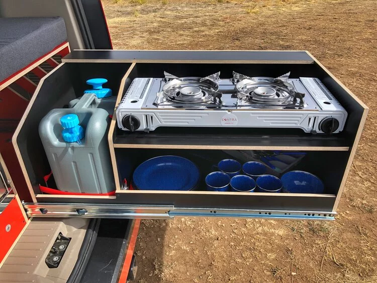 A simplified version of the common dual-burner stove and sink set-up, Contravans uses a dual-burner multi-fuel camping stove and a pressurized water canister with faucet