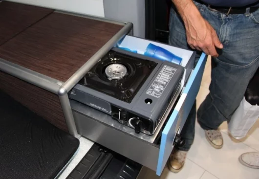 Sliding stove and refrigerator compartment round out the camping utilities