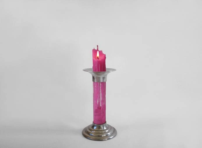As the candle burns at the top, the melted wax collects at the bottom