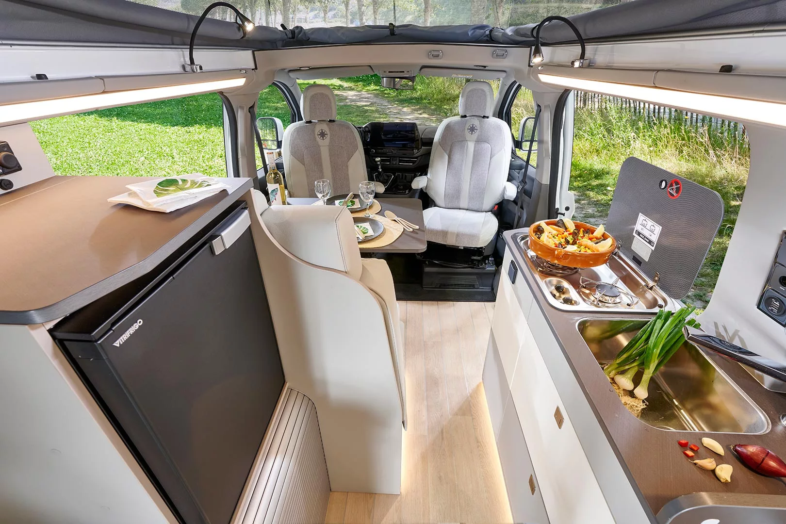Both the dual-burner stove and sink have lids that function as worktops, and the top of the fridge console adds another space to work and store things while cooking