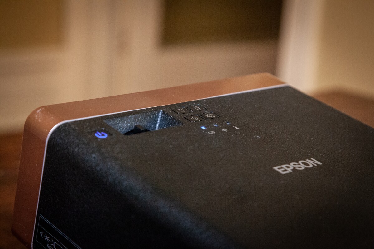 The Epson EF-100 is a stylish addition to a lounge room in our view, with the rounded corners, copper accents and faux-leather finish