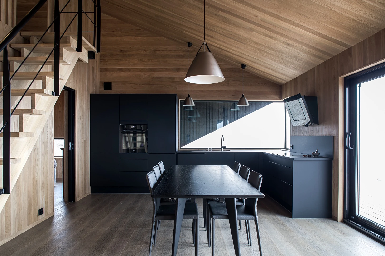 Inside, the cabin is arranged around an open living area with a living room, kitchen, and dining area