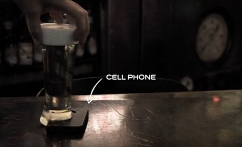 The concept of the Offline Glass explained in visual form, with a smartphone wedged under the beer to keep it upright