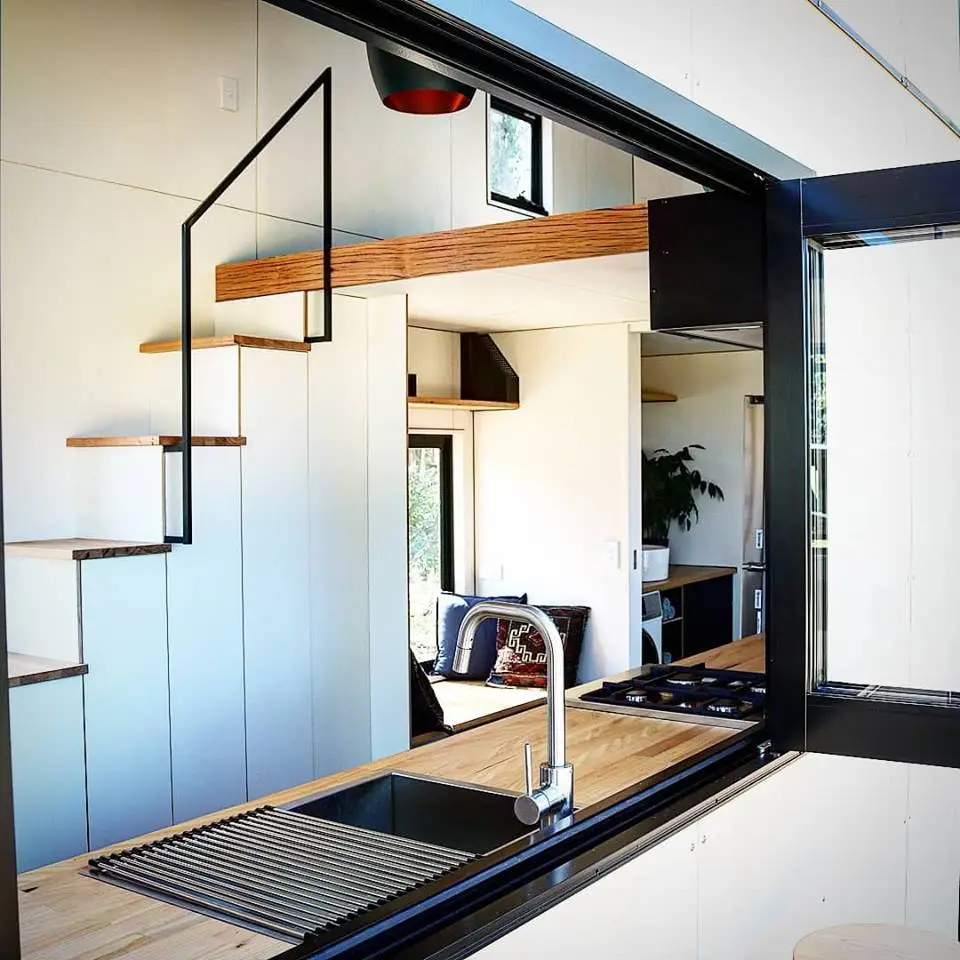 Gorgeous minimal kitchen opens up onto the Sowelo tiny home's external decking