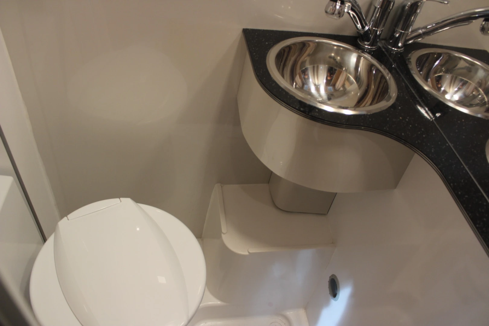 The StarCamper has a bathroom with corner toilet/sink and extended shower floor
