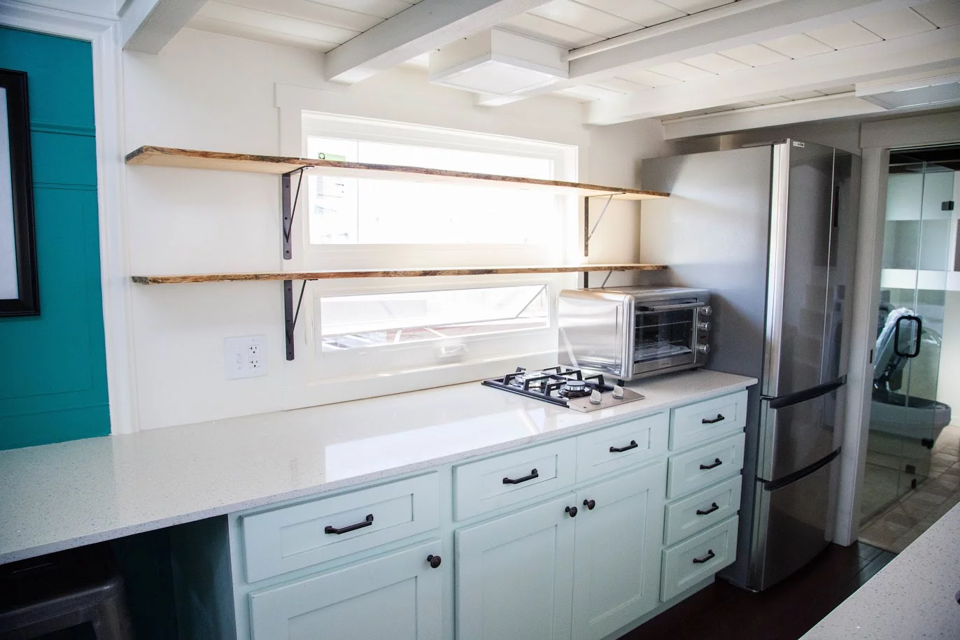 El Gato's kitchen includes a propane-powered two-burner stove, microwave, and shelving
