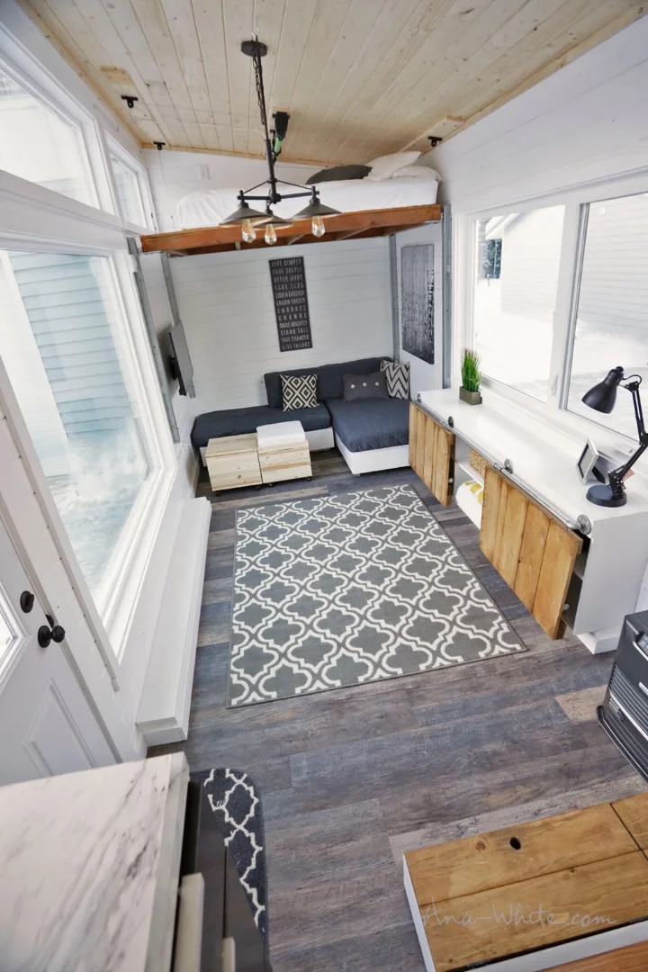 The Open Concept Rustic Modern Tiny House's elevating bed in its most raised position