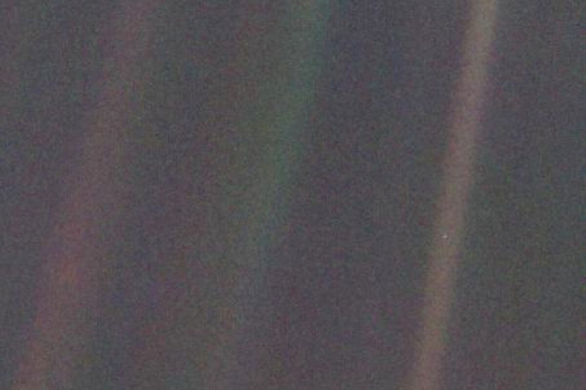 Voyager 1's iconic pale blue dot, with Earth featured as a tiny spec in the light band on the right of the image