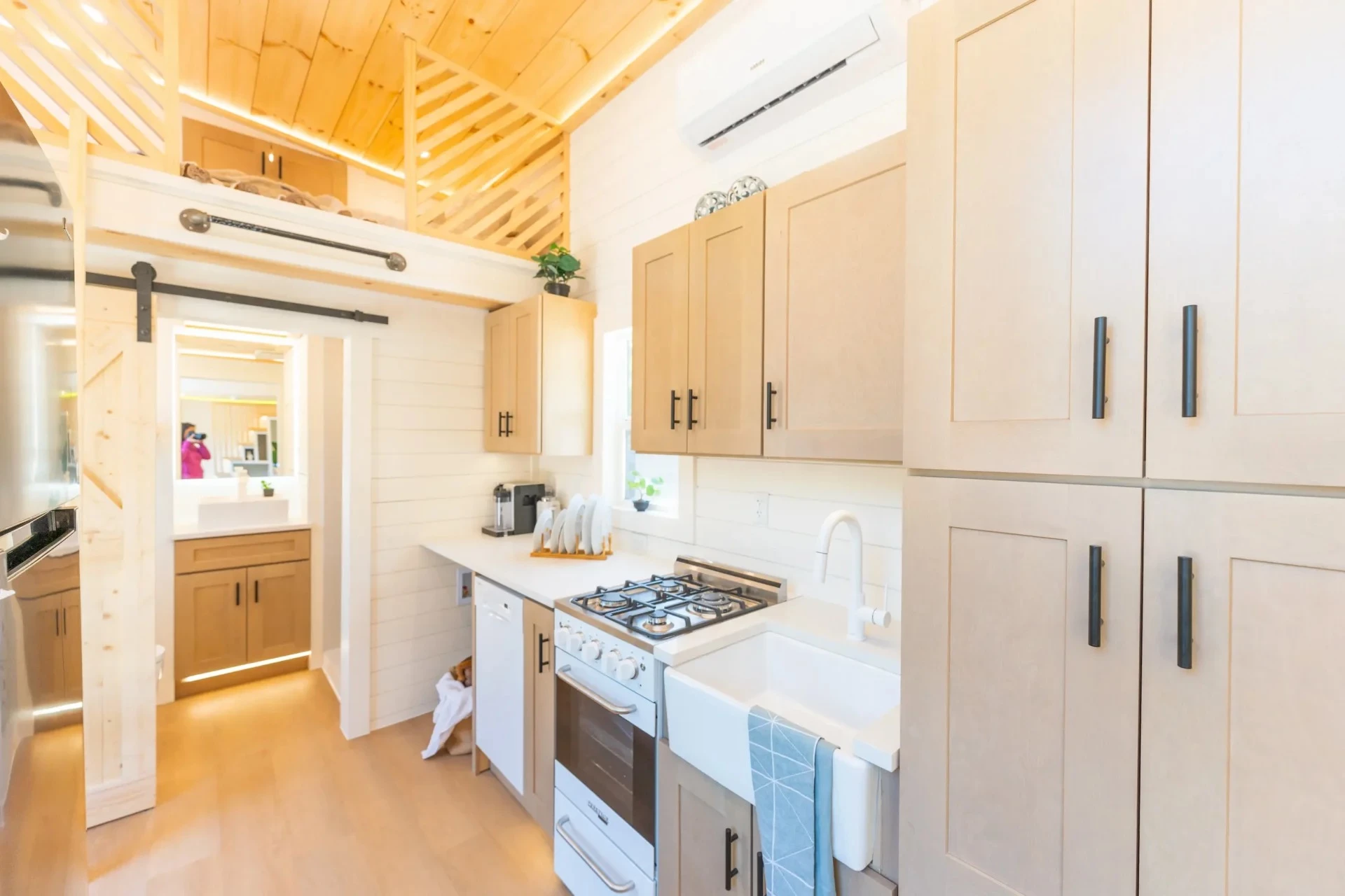 The Premium Vista's kitchen includes an oven with a four-burner propane-powered stove, plus a farmhouse-style sink, a fridge/freezer, and a dishwasher