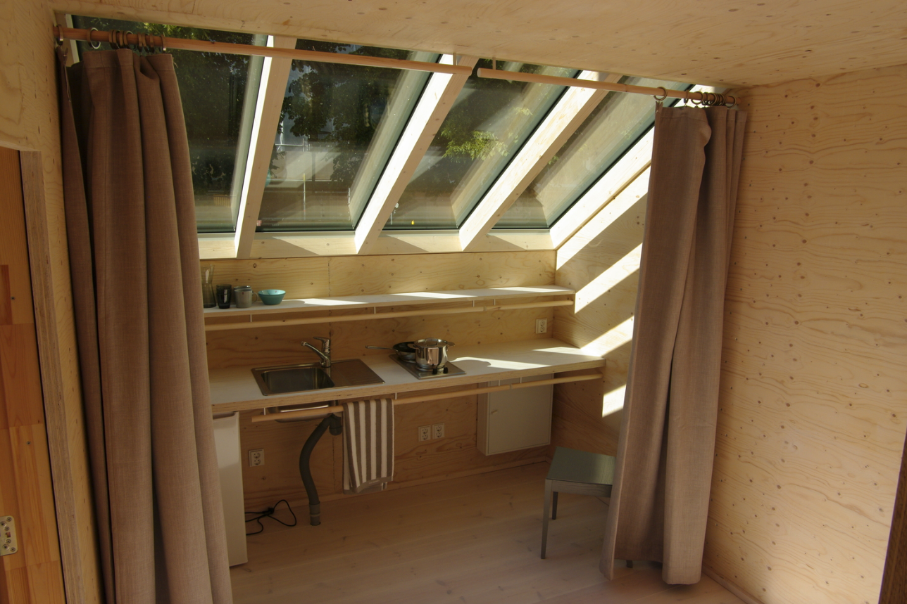 The interior includes a dining area, kitchen, bathroom, and bedroom over its three floors