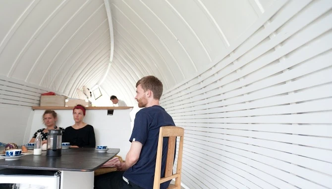 The small 25 square meter (269 square ft) home features intricate wooden flooring and curved surfaces