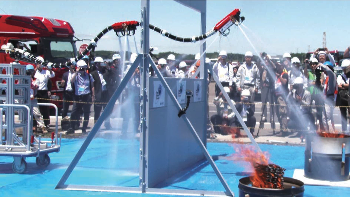 The robot flies over a wall to shoot water at some test barrels.