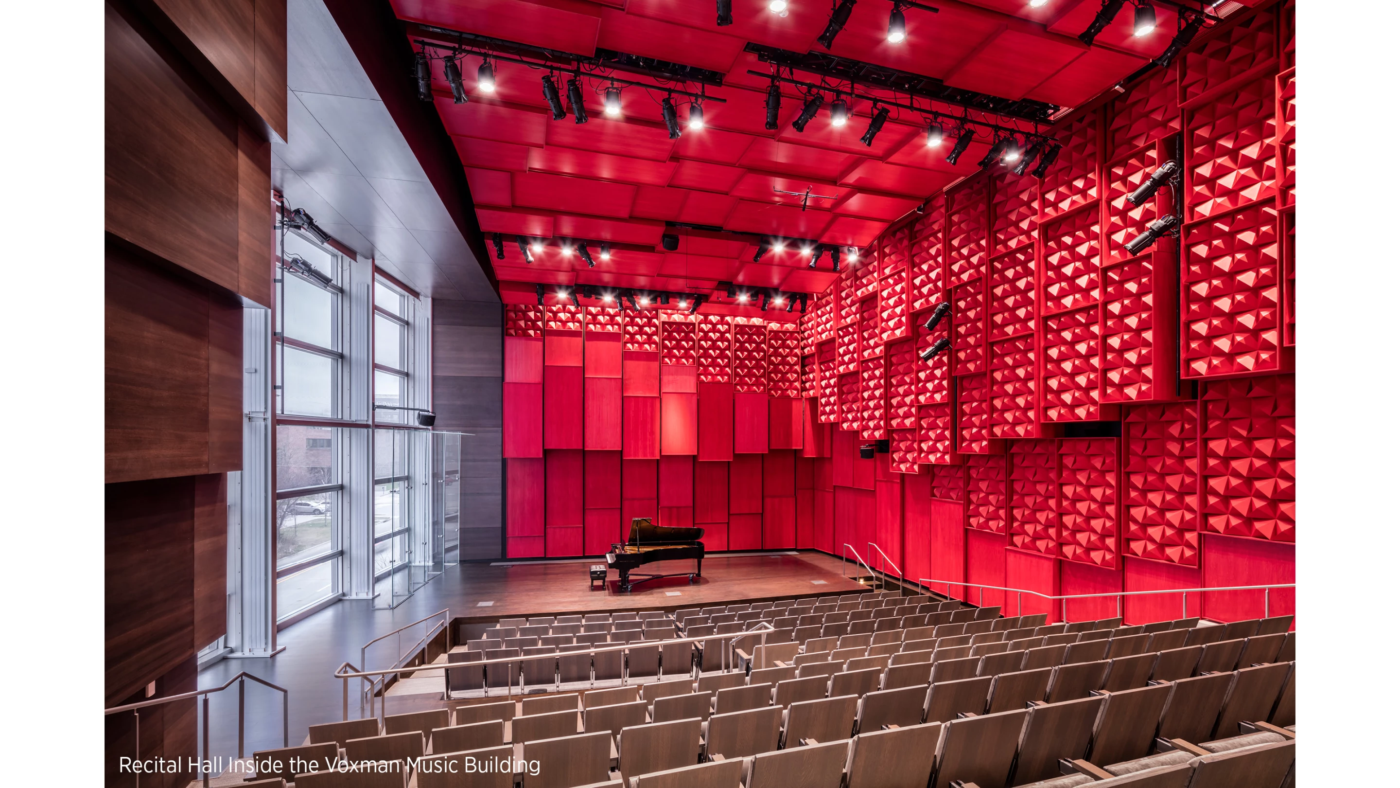Voxman Music Building includes a 700-seat concert hall, a 200-seat recital hall, and supporting spaces like rehearsal rooms. Extensive glazing allows views of the surrounding community