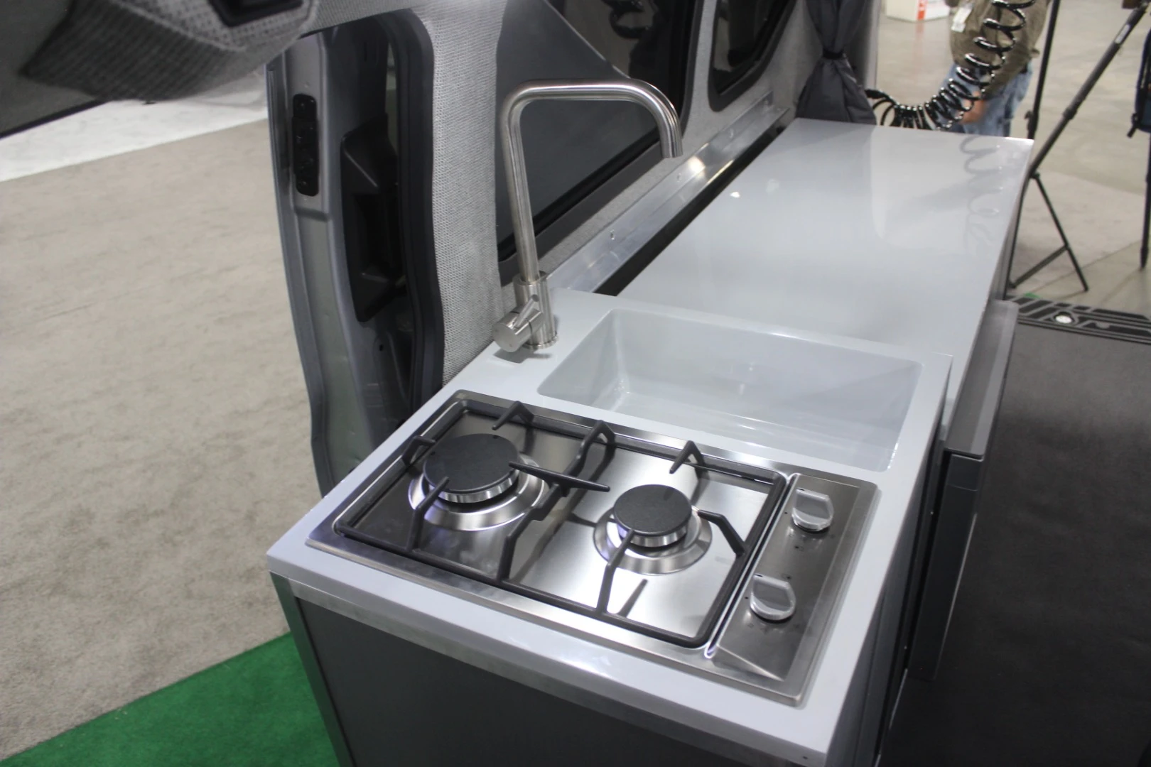 The kitchen area looks a little different, but still includes a dual-burner stove, sink and fridge