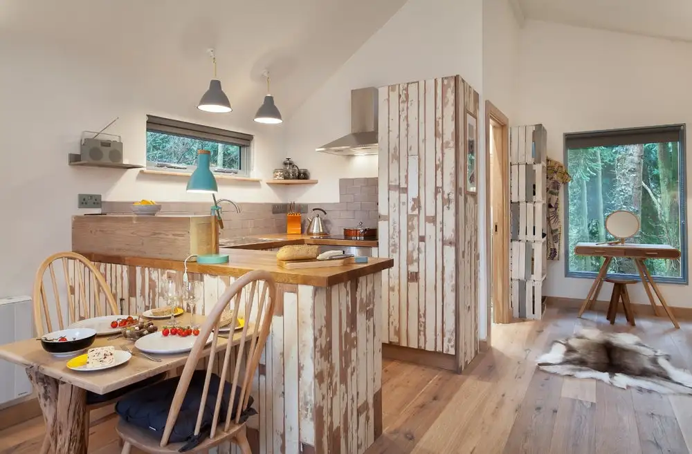 Kitchen inside the Bird house in Somerset, England, a solar-powered treehouse-style dwelling supported by sections of tree trunk stilts and accessed via wooden steps