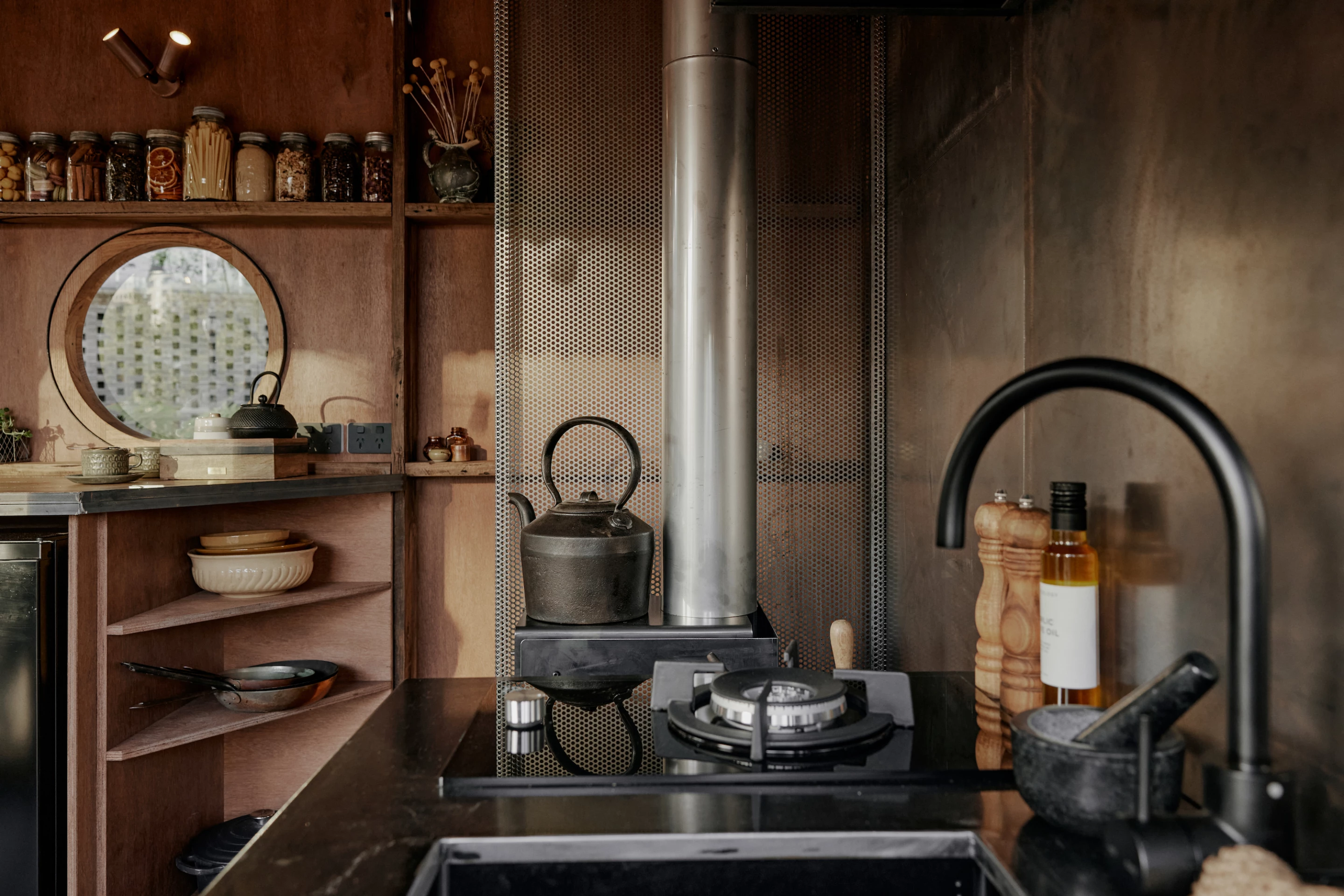 Stella the Stargazer's kitchen includes a propane-powered stove, a small fridge, sink, and shelving