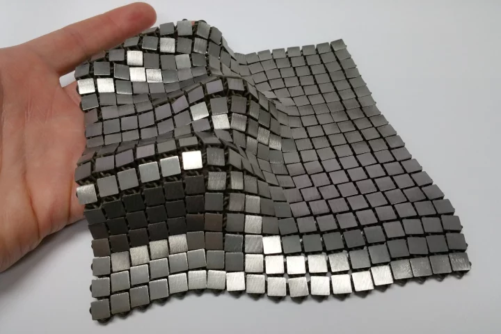 The metallic "space fabric" that was created using 3-D printing techniques that allow different functionality to be integrated into each side of the material