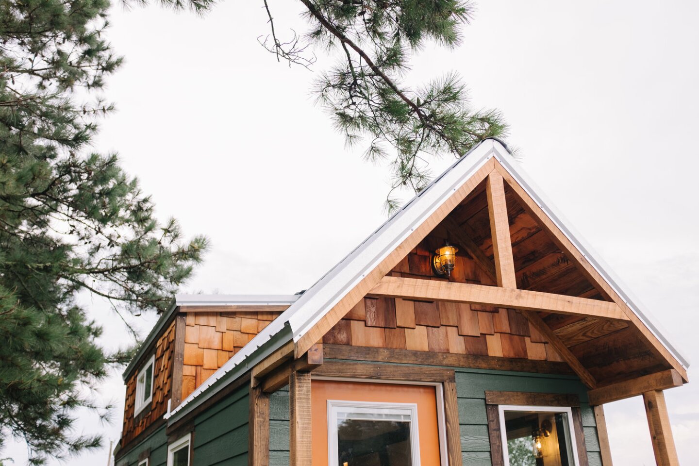 The exterior of the Acadia tiny house features rough cut oak and pine, creating a rustic feel