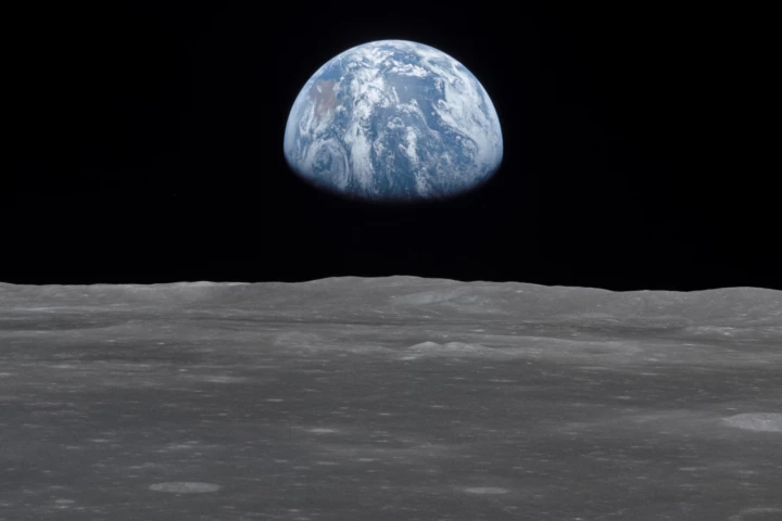1969 photo of the lunar surface, with Earth rising on the horizon