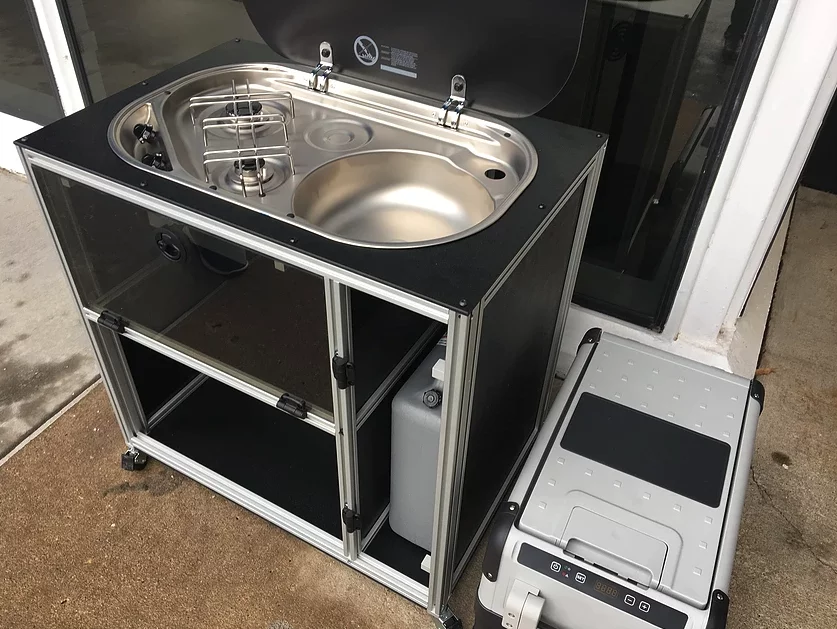 The kitchen unit can mount inside the van or be used outside