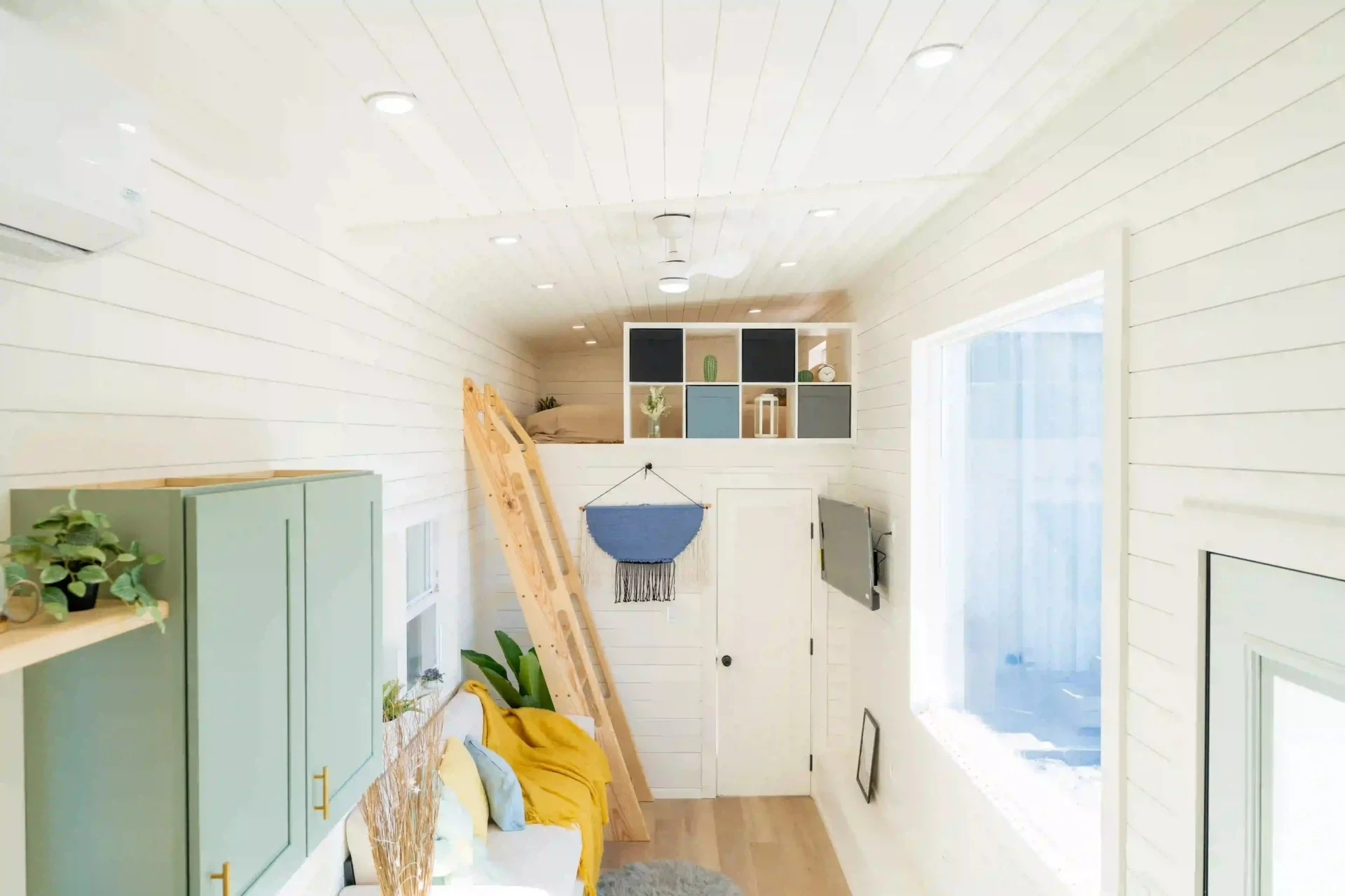 The living room in the Avalon 32' includes a sofa with integrated storage, plus there's a wall-mounted TV