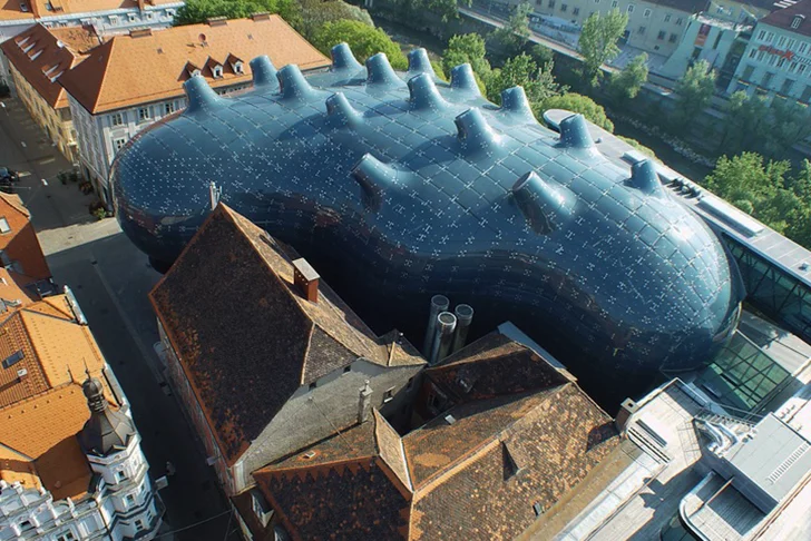 The Kunsthaus Graz is an art museum in Austria that resembles a strange alien blob sitting among traditional European buildings