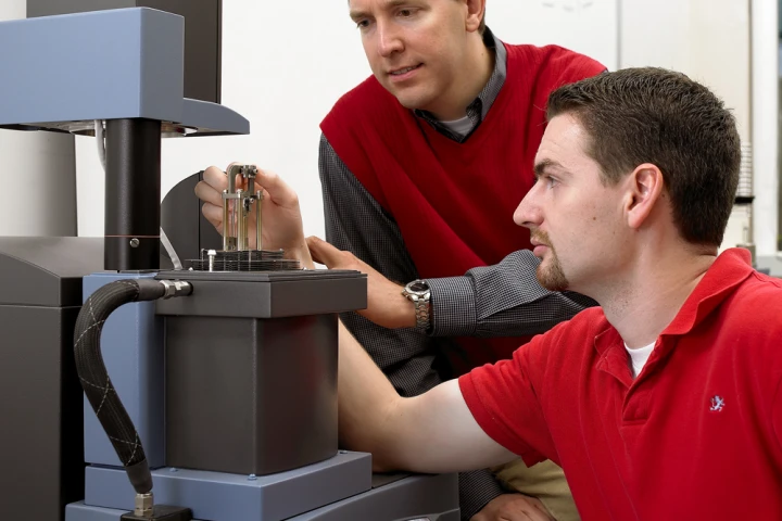 Michael Kessler (left) and former Iowa State doctoral student Will Goertzen use a dynamic mechanical analyzer to measure the mechanical properties of polymers (Photo: Michael Kessler)