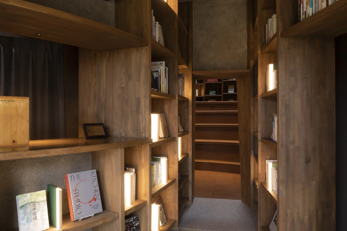 Passing through a series of twisting walkways, bookshelves rise up to the ceiling