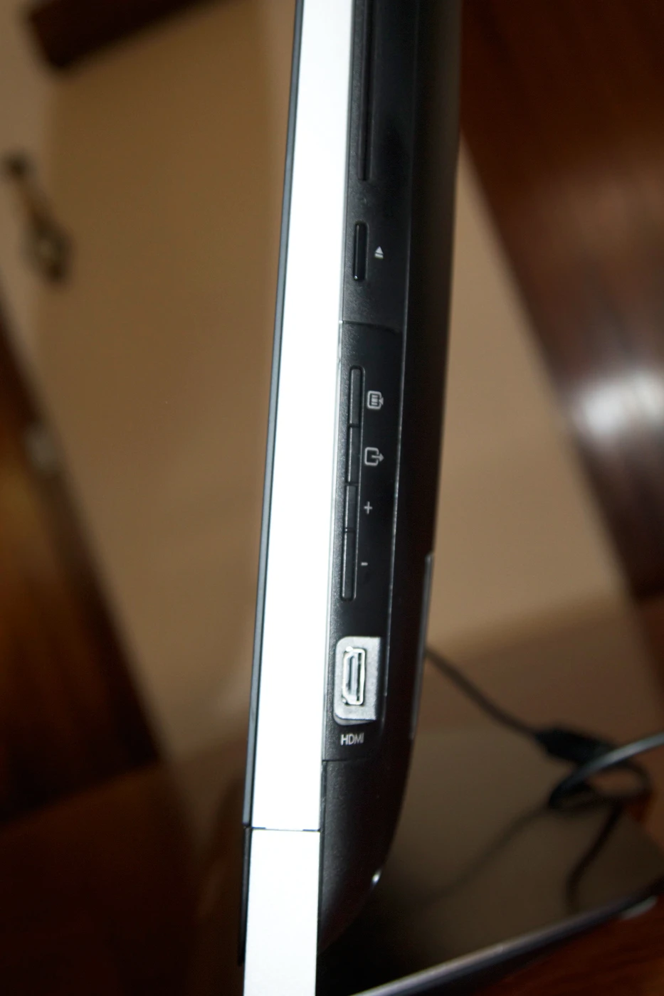 The slot-loading optical drive, volume and input control buttons and optional HDMI input are found on the right side of the unit