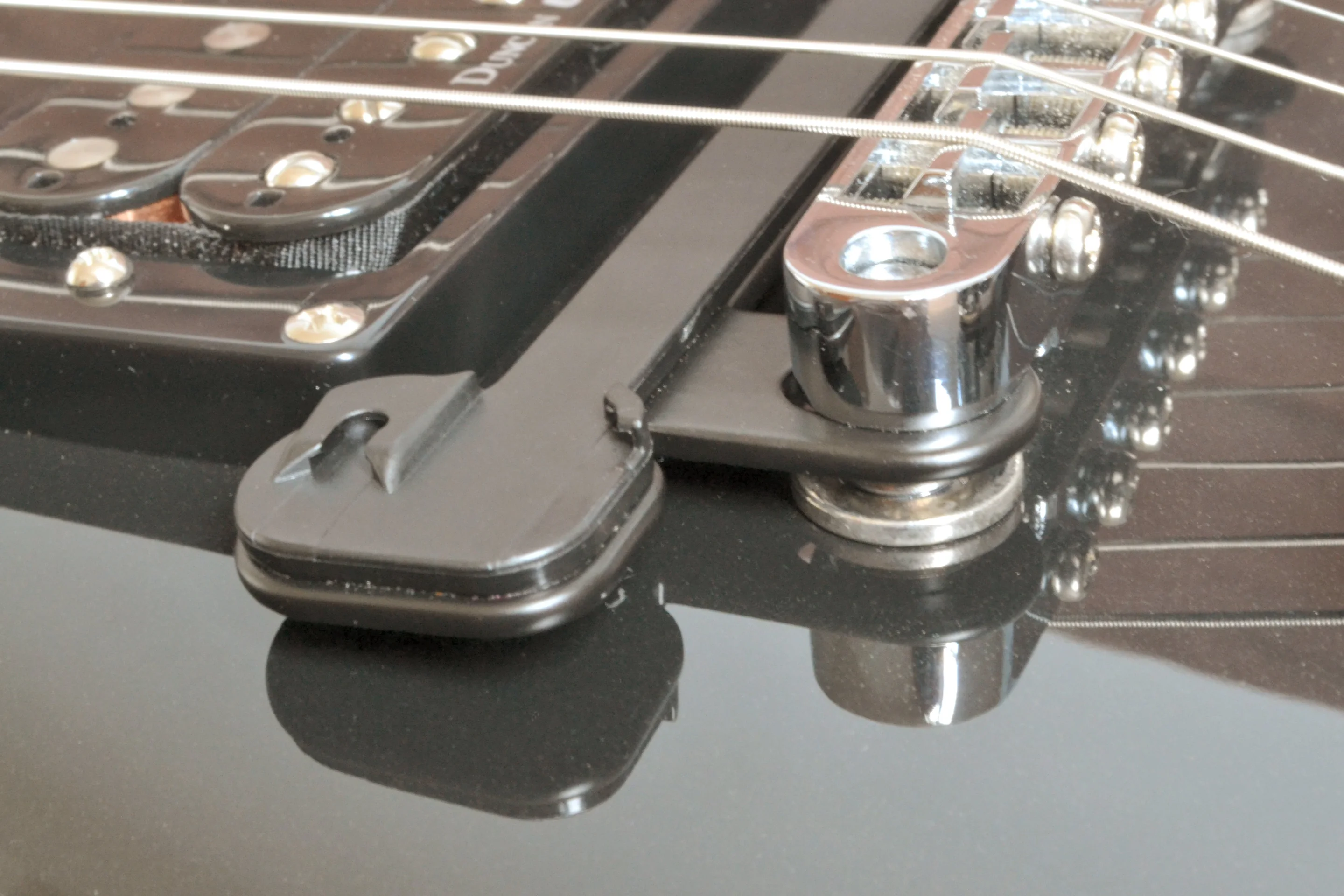 A Tune-o-matic bridge bracket allows installation without the mild adhesive of the pickup mounting pad getting anywhere near the guitar's finish (Photo: Paul Ridden/Gizmag)