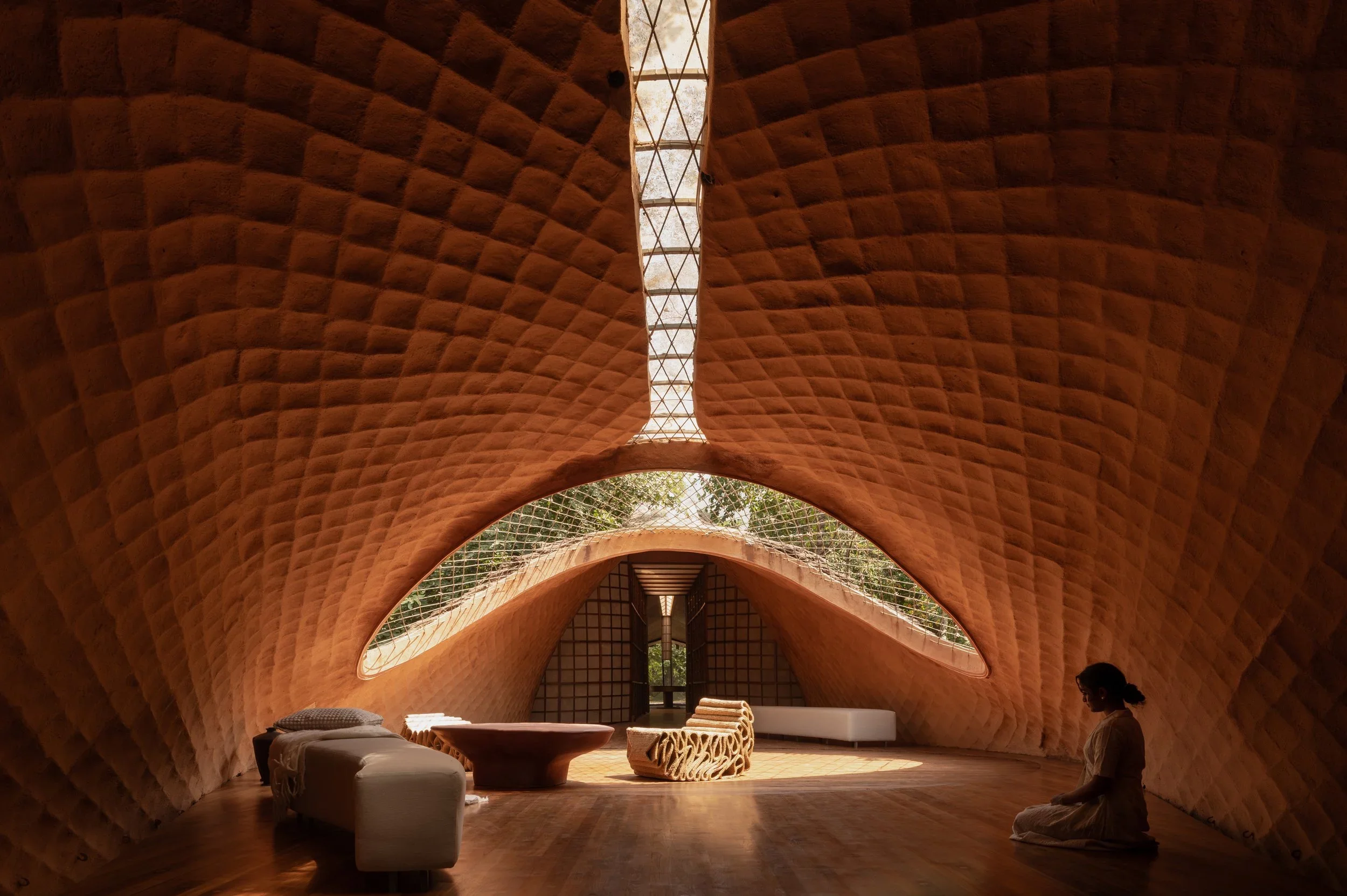 "The thatch layer inspired by the scales of a pangolin, providing thermal insulation and effective cooling also allowed us to push for a long-span, lightweight structure with just 4 footings, ensuring very less intrusion into the natural contour of the land"