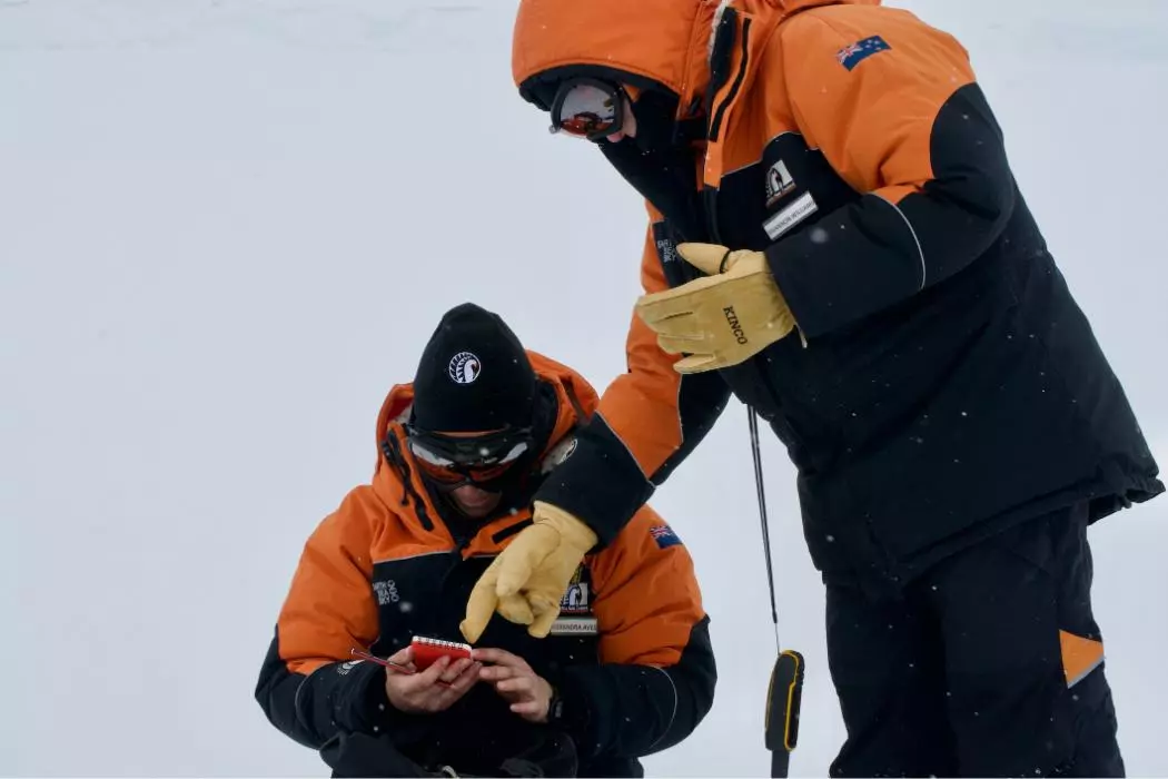 Researchers log details of a snow sampling site in Antarctica