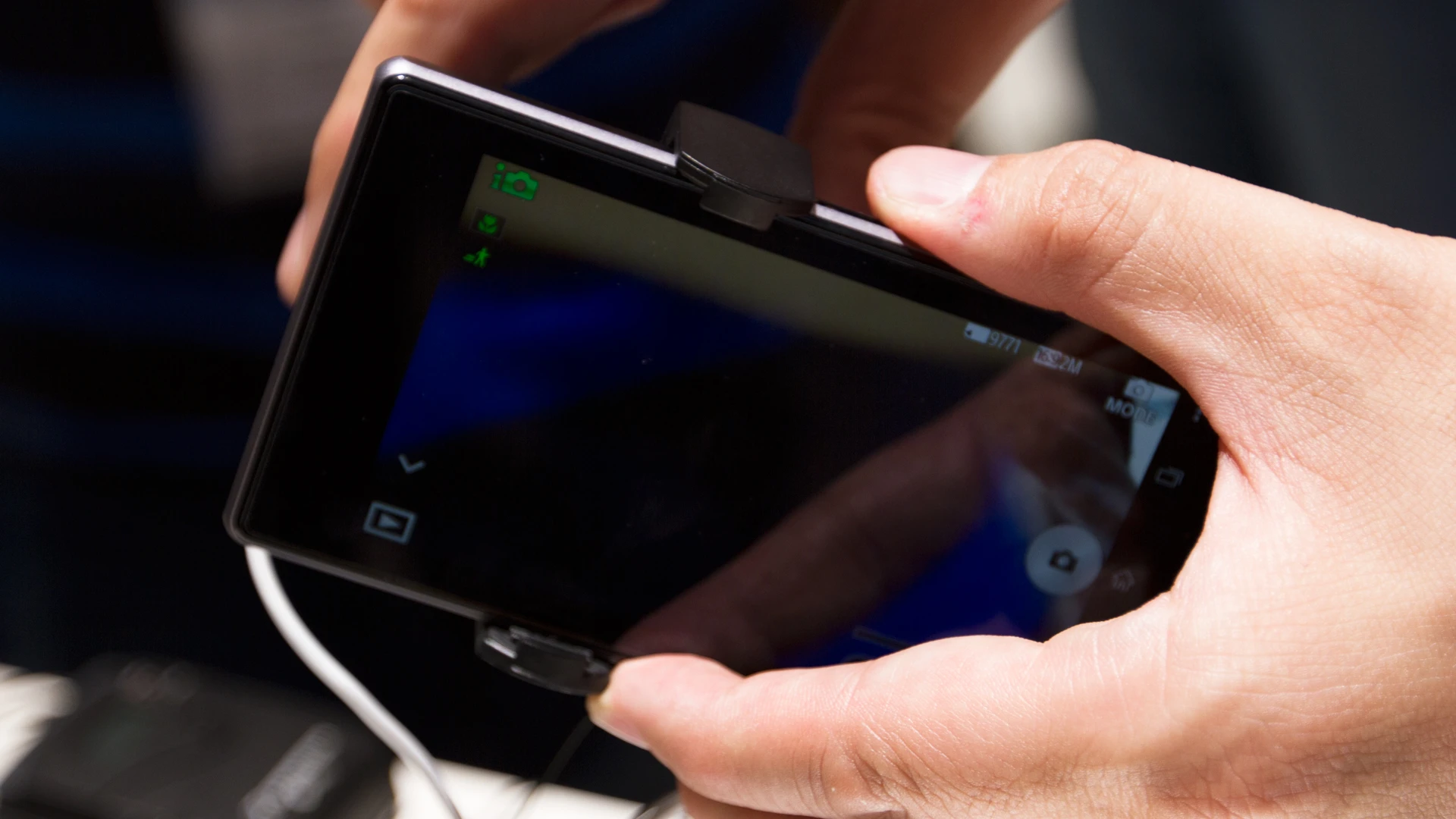 The adapter clamps the camera onto the mobile device