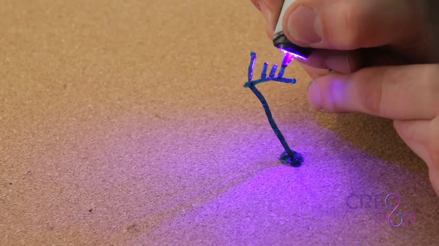 The UV hardens the gooey "cool ink" paste coming out of the nozzle